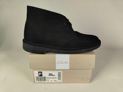 Black Clarks Originals Desert Boot on a Clarks shoe box with a beige background