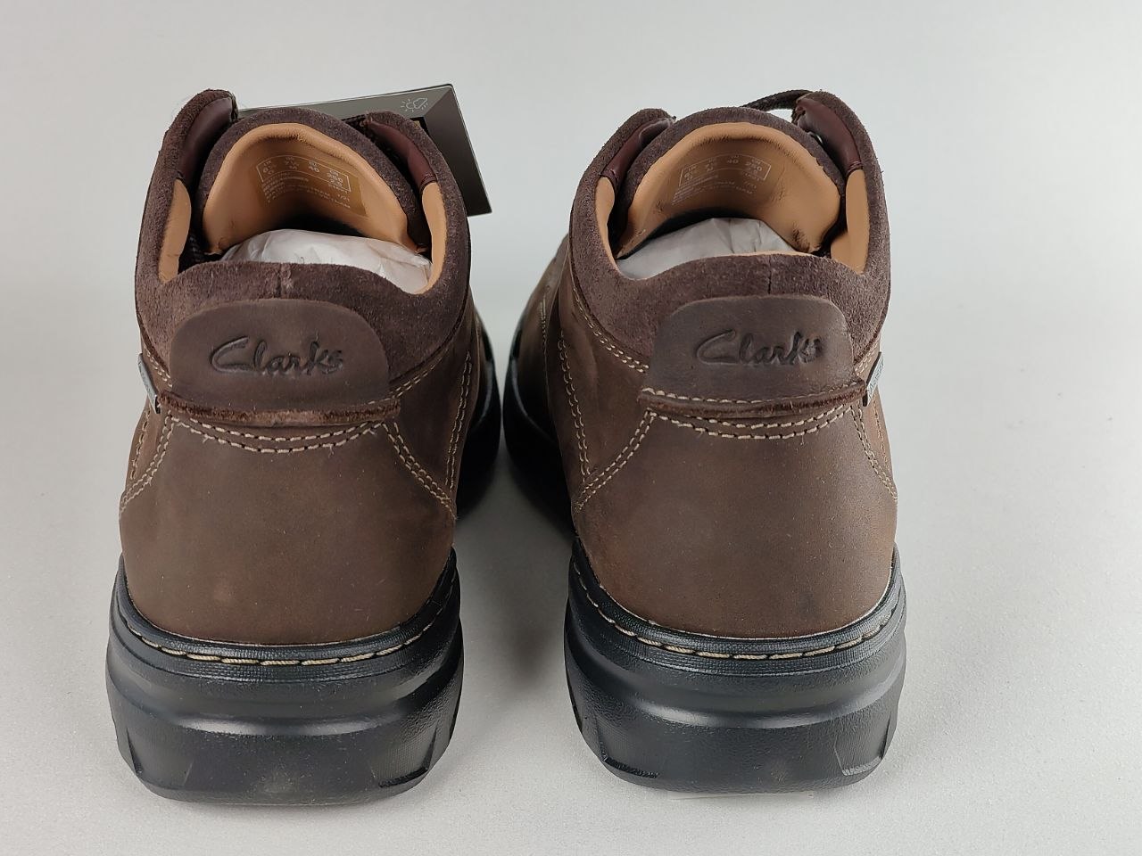 Pair of brown Clarks shoes on a light gray background