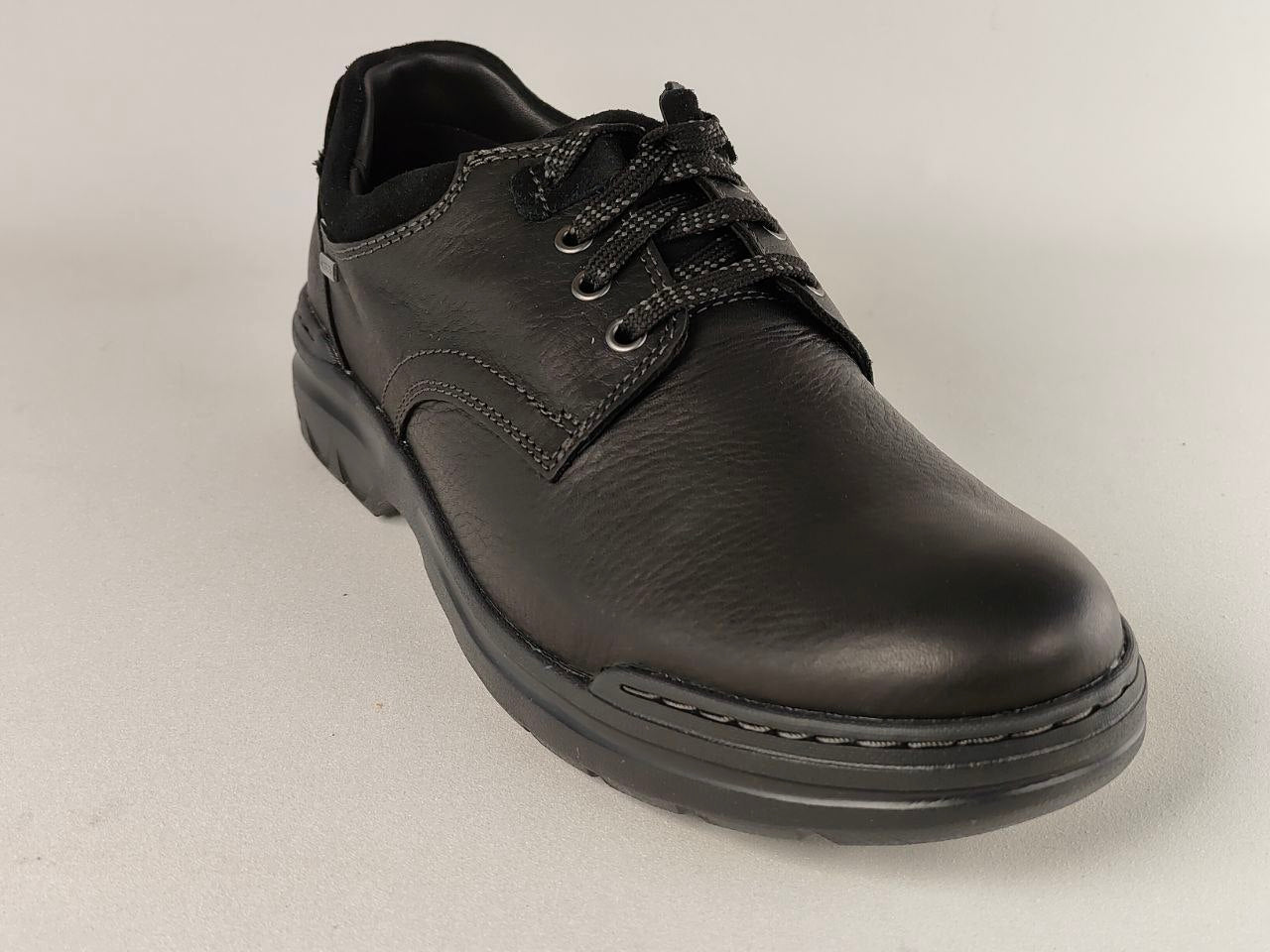 Black leather shoe on a light gray background