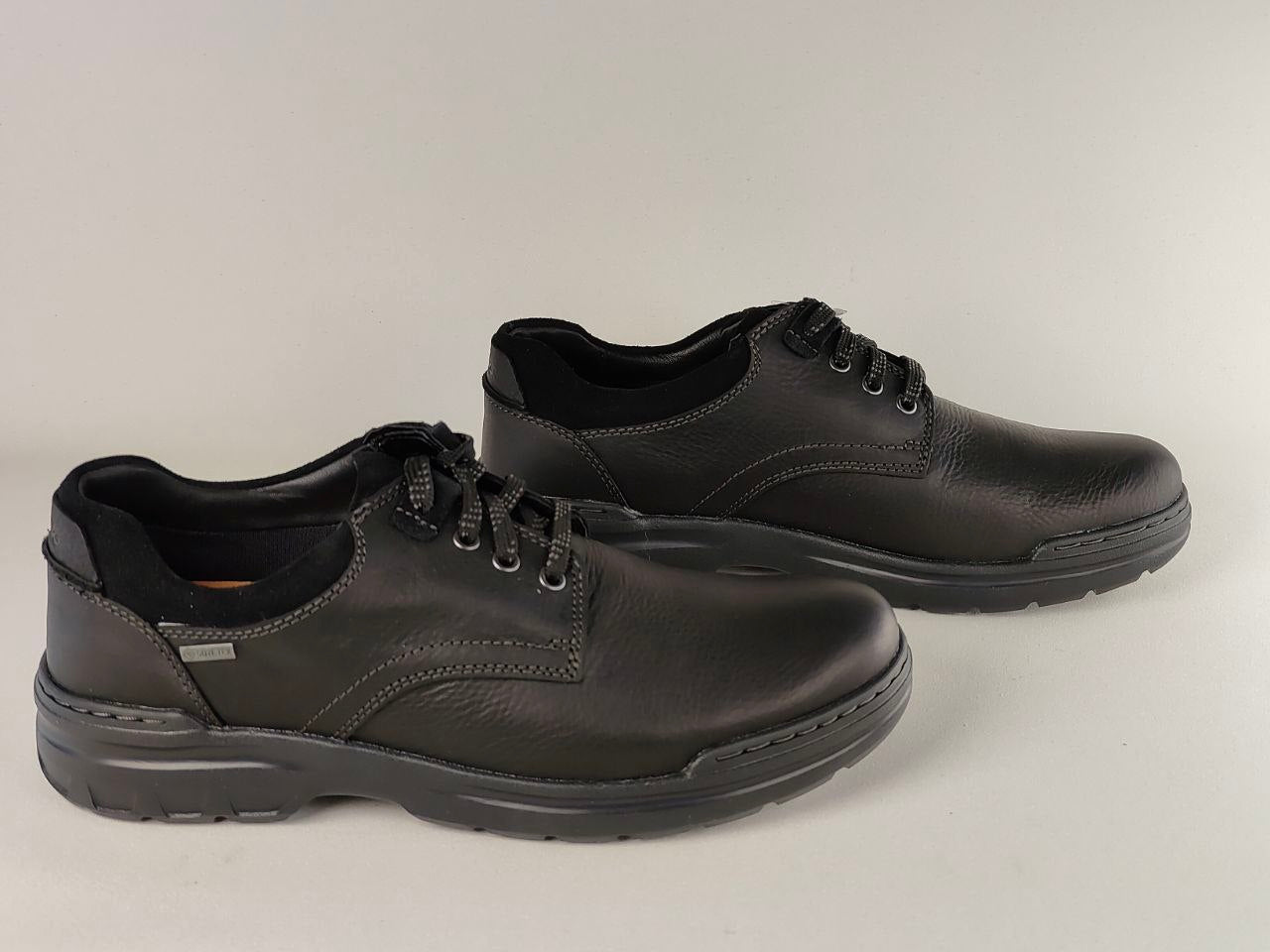 Pair of black leather shoes on a light gray background