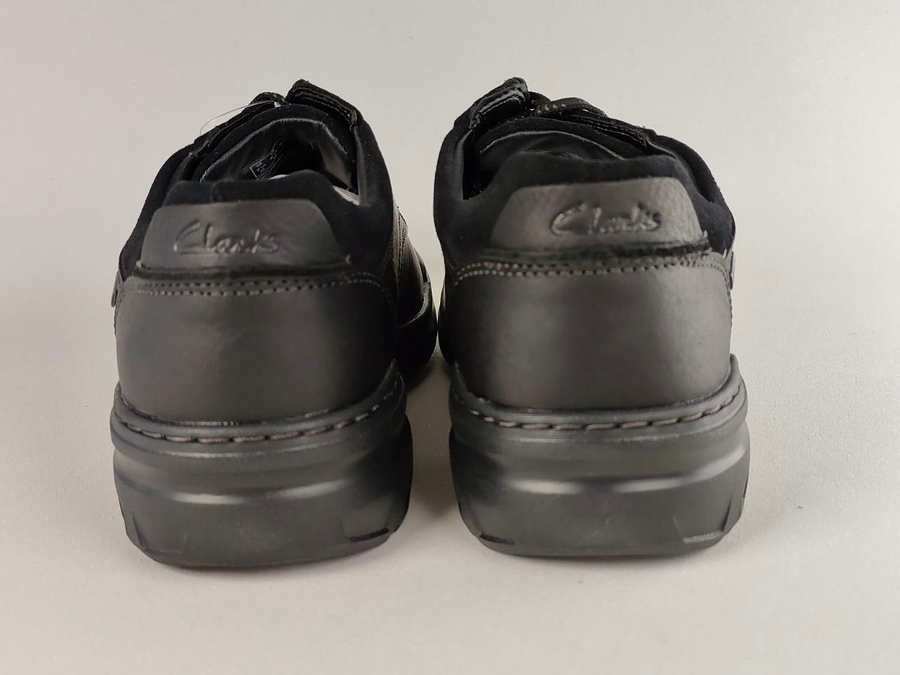 Pair of black Clarks shoes on a light gray background
