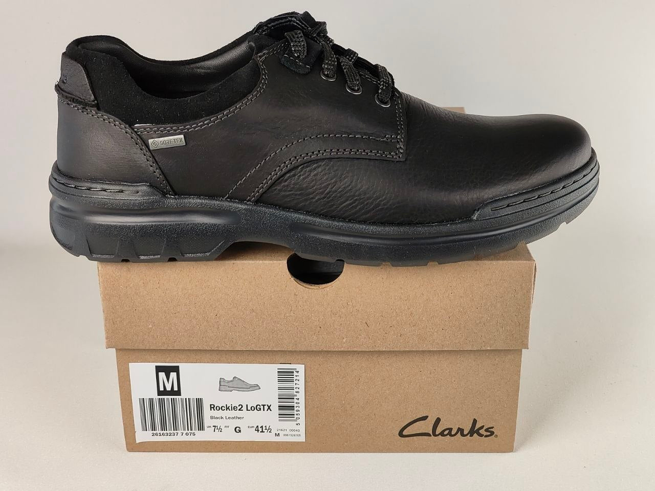 Black Clarks shoe on a cardboard box with a white background