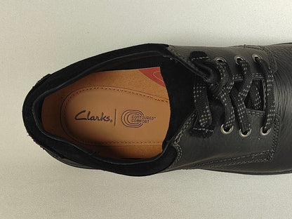 Black leather shoe with Clarks logo on a light gray background