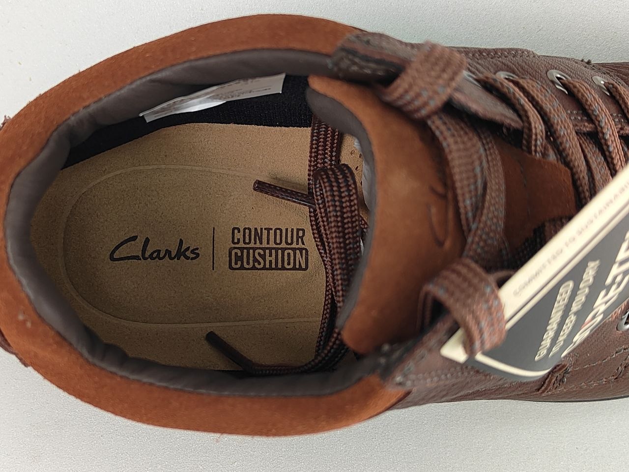 Brown leather shoe with 'Clarks' branding on a white background