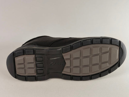 Black shoe sole with tread pattern on a light gray background