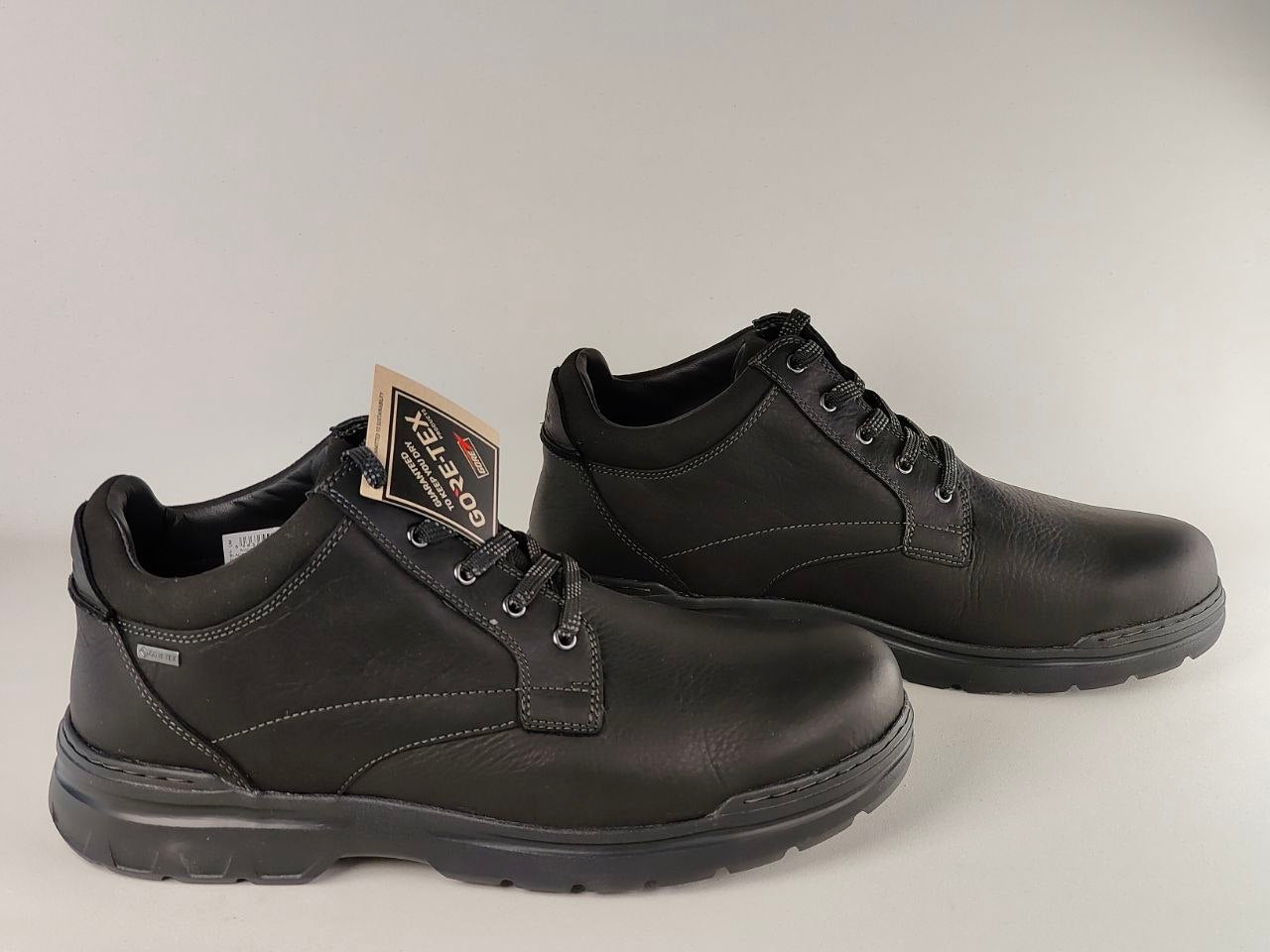 Pair of black leather boots on a gray background