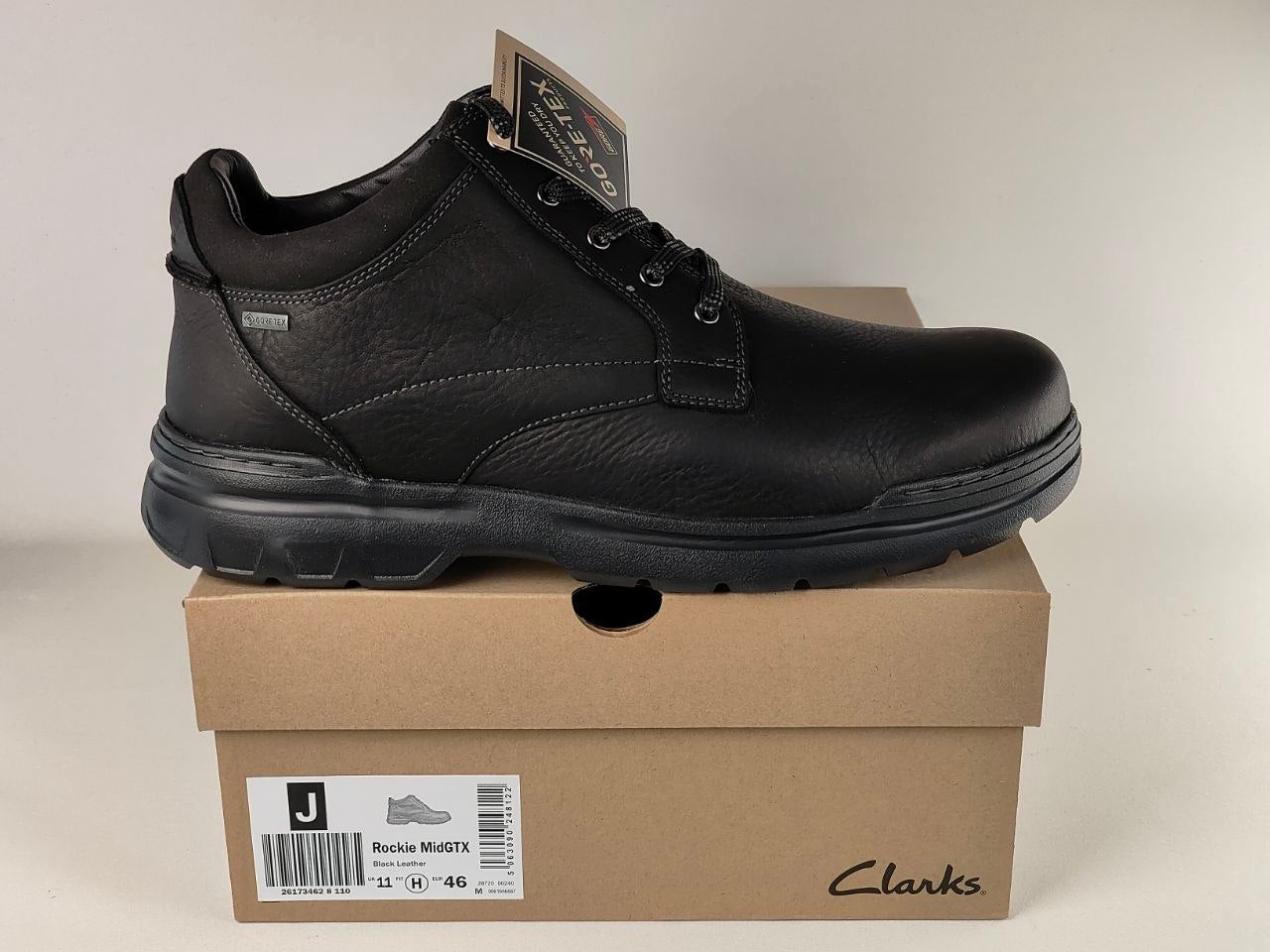 Black leather shoe on a Clarks box with a beige background