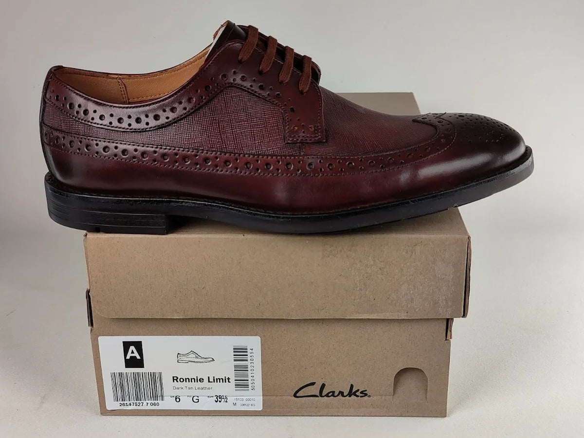 A dark tan Clarks Ronnie Limit Men's Full Grain shoe on a Clarks box with a plain background - detail view @runinrain