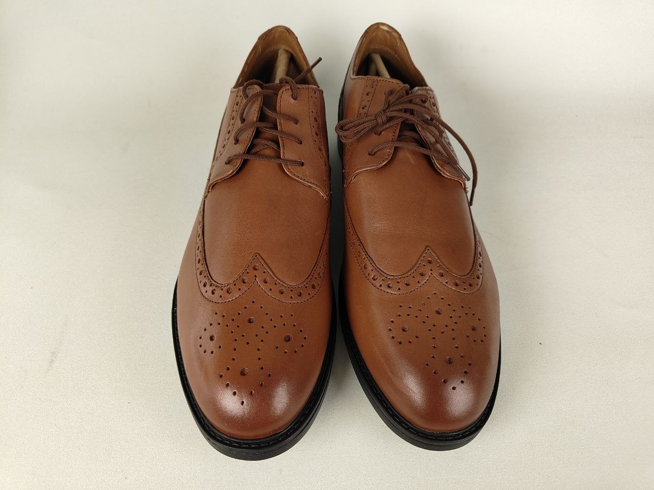 A pair of Clarks Beckfield Limit Men's Tan Leather Wingtip Brogue shoes on a white background - front view @runinrain