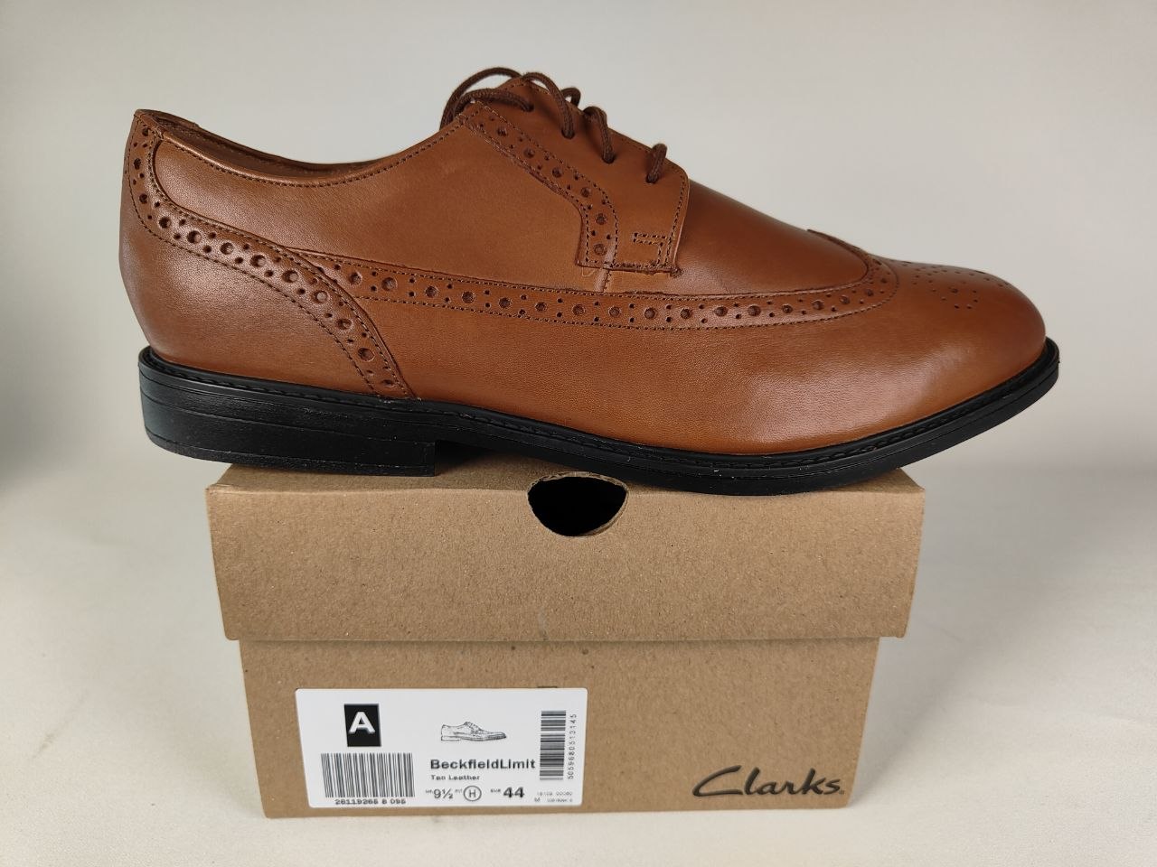 A Clarks Beckfield Limit Men's Tan Leather Wingtip Brogue shoe on a Clarks branded box on a white background - detail view @runinrain