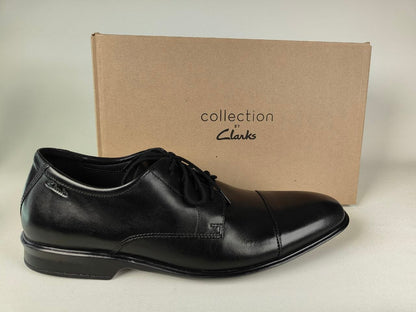 A Clarks Bensley Cap Men's Black Leather Oxford shoe in front of a Clarks Collection branded box on a light gray background - Side shot @runinrain