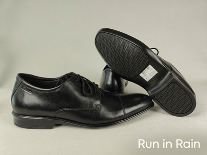 A Clarks Bensley Cap Men's Black Leather Oxford sole on a pair of Clarks Bensley Cap Men's Black Leather Oxford on a light gray background with 'Run in Rain' text – sole view @RunInRain