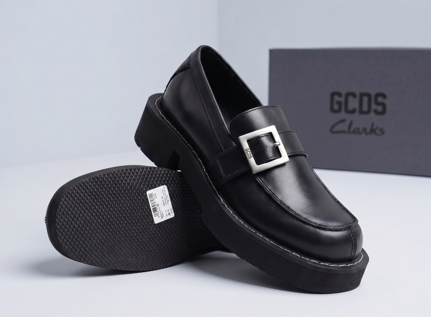 GCDS x Clarks 1 black leather loafers with silver buckle detail and chunky lug sole, displayed with GCDS box - brand shot @runinrain