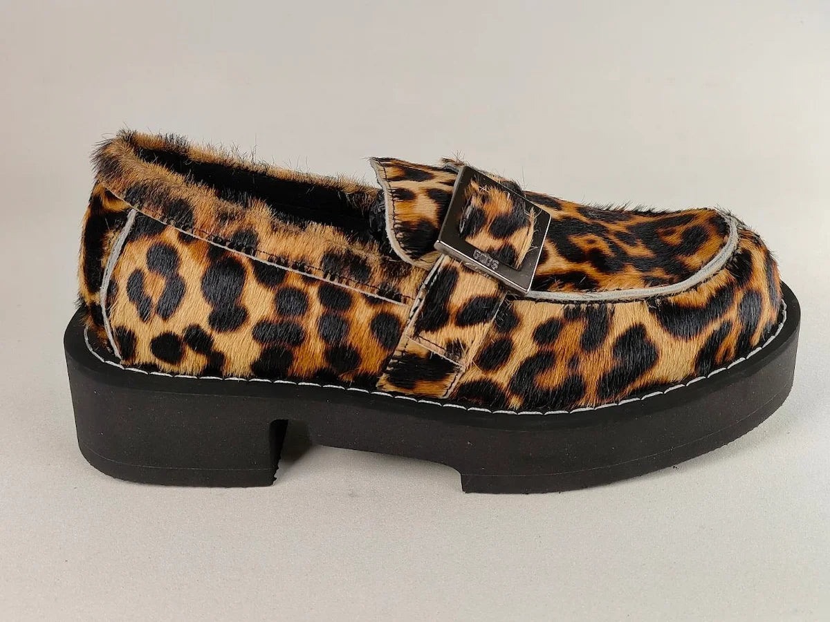 Leopard print loafer with a black platform sole on a light gray background