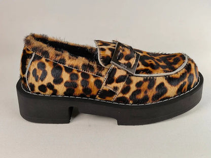 Leopard print loafer with a black platform sole on a light gray background