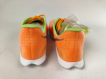 Pair of orange HOKA Cielo X 2 MD track spikes with green accents on a light gray background