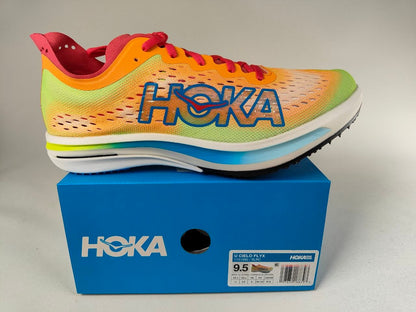 A Hoka Cielo FlyX Carbon-Plated Track Spikes Solar Flare with red laces on a blue box with a white Hoka branding on a light gray background – detail View @RunInRain 