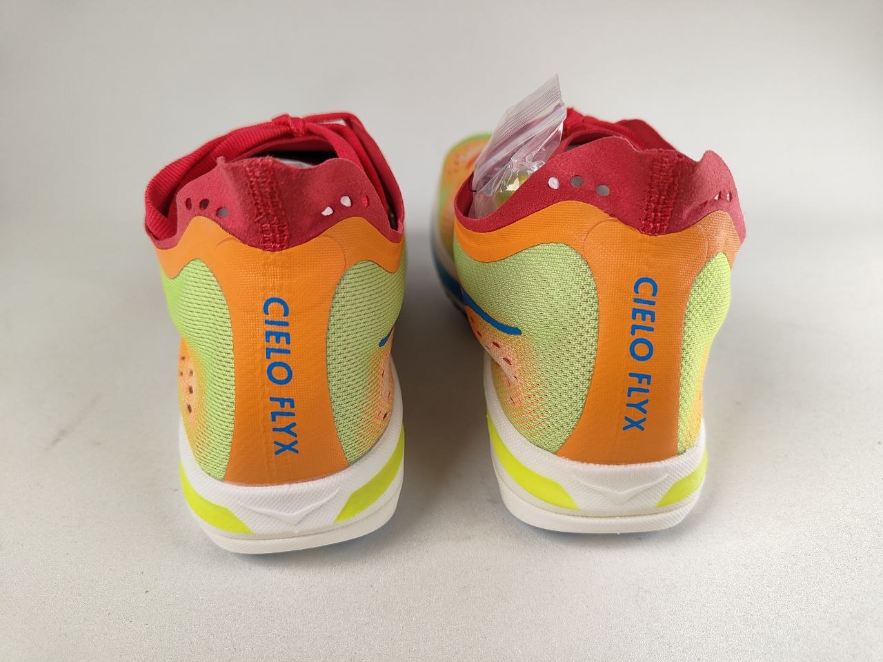 Hoka Cielo FlyX Carbon-Plated Track Spikes Solar Flare with Cielo Flxx branding – Rear View | RunInRain