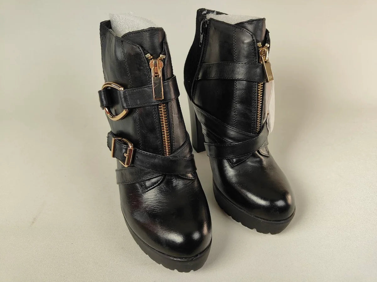 A pair of La Strada Elite High-Heel Platform Ankle Boots in black leather with buckles and zippers on a light gray background - Front view @runinrain