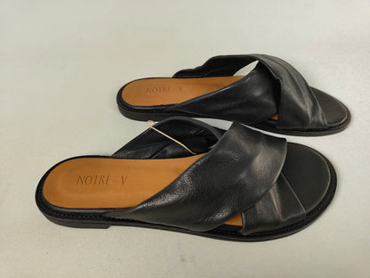 A pair of black Notre-V Elegant Criss-Cross Black Leather Women sandal with open toe on a light gray background – Side View @RunInRain