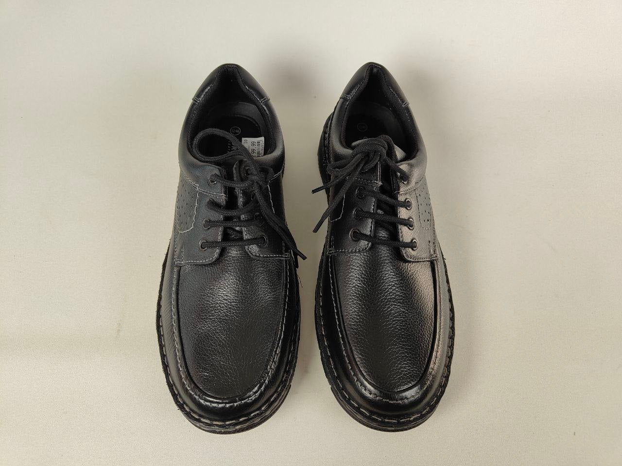 Pair of black Orchard Anatomical Leather Loafers shoes on a light beige background