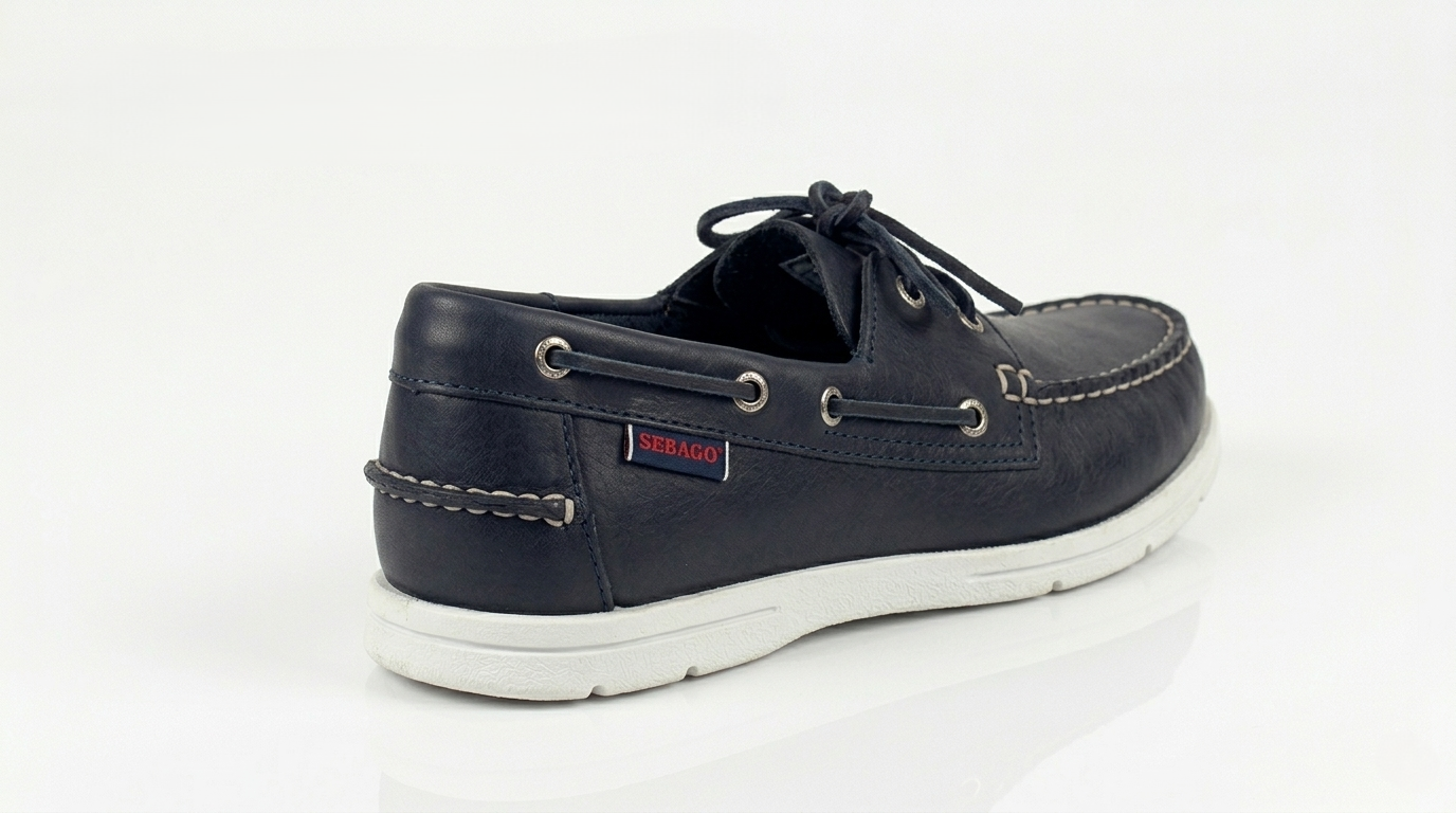 A navy blue Sebago Docksides Portland Women's Nautical Loafers shoe with white laces and a SEBAGO brand on a white background – Sole View @RunInRain