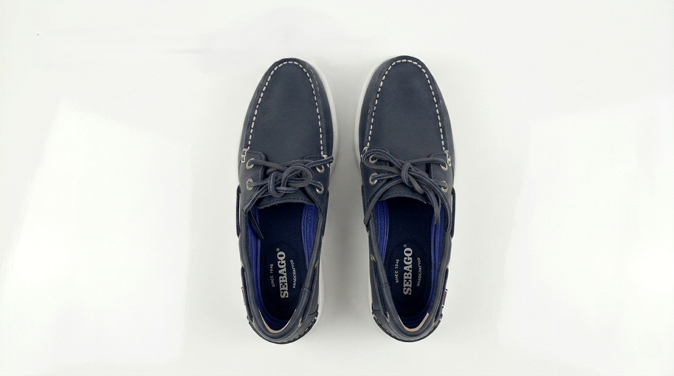 Pair of navy blue Sebago Docksides Portland Women's Nautical Loafers with white laces on a white background – Sole View @RunInRain