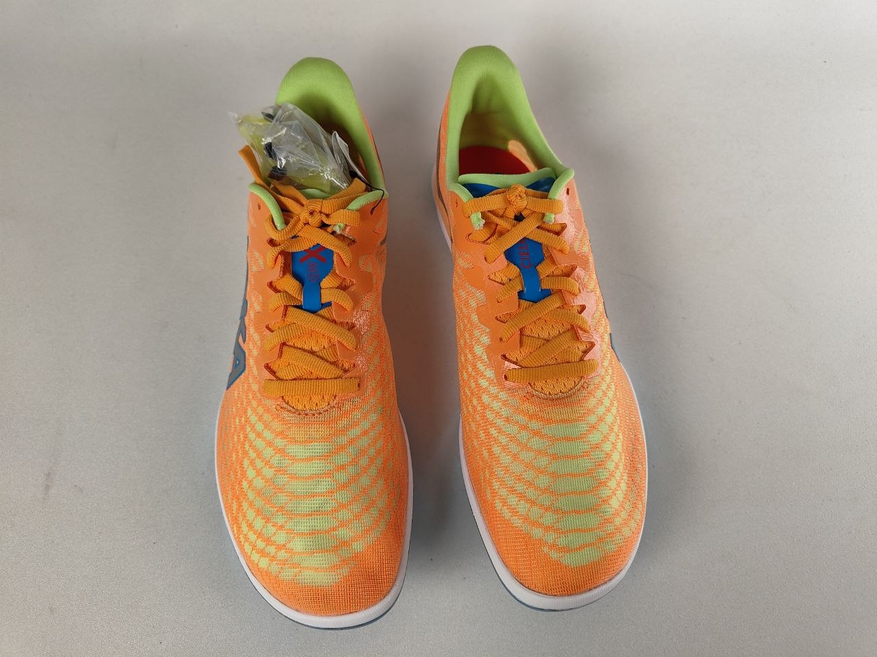 Orange running Hoka Cielo X 2 MD track spikes with green accents on a light gray background - Top view