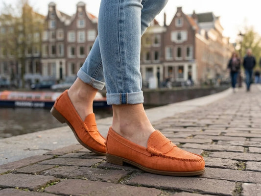 Person wearing Sebago Plaza Women's Orange Leather Loafer on a cobblestone street with buildings in the background - free style @runinrain